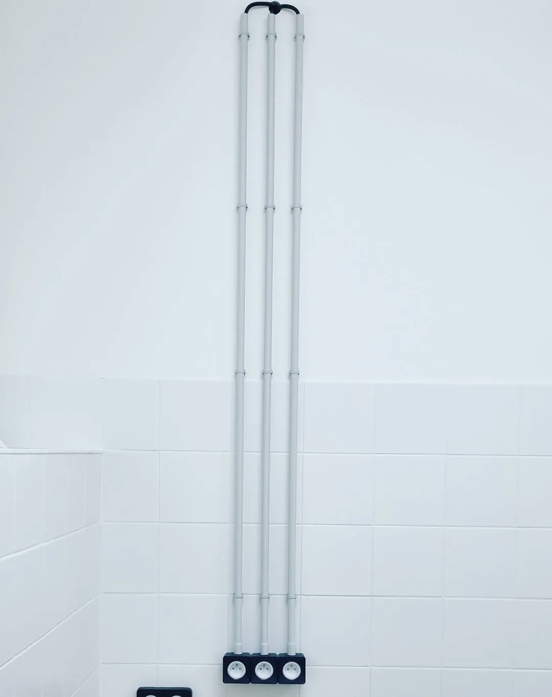 Conduits apparents et prises électriques posés dans un angle de pièce